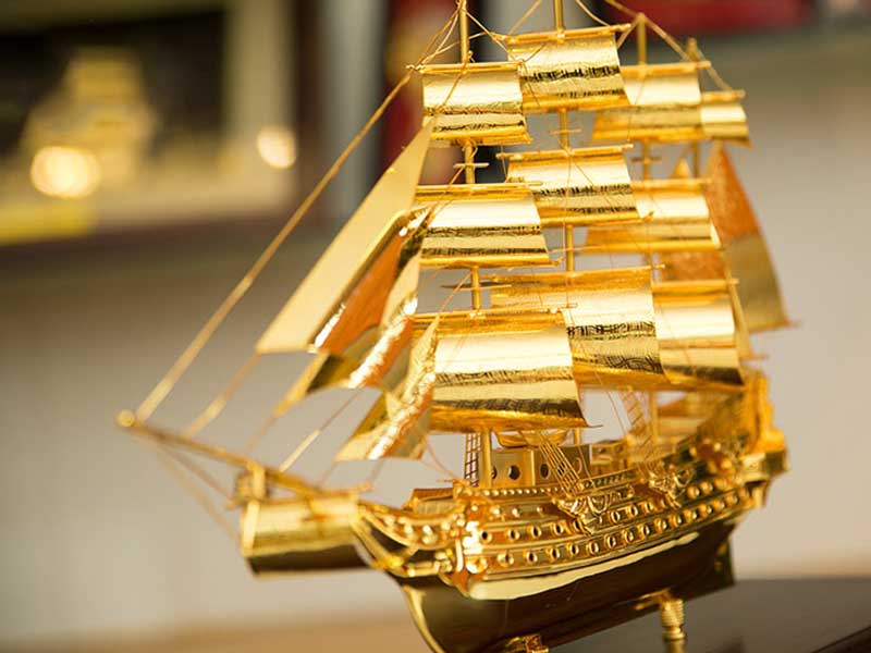 Thuyền buồm vàng để bàn làm việc văn phòng